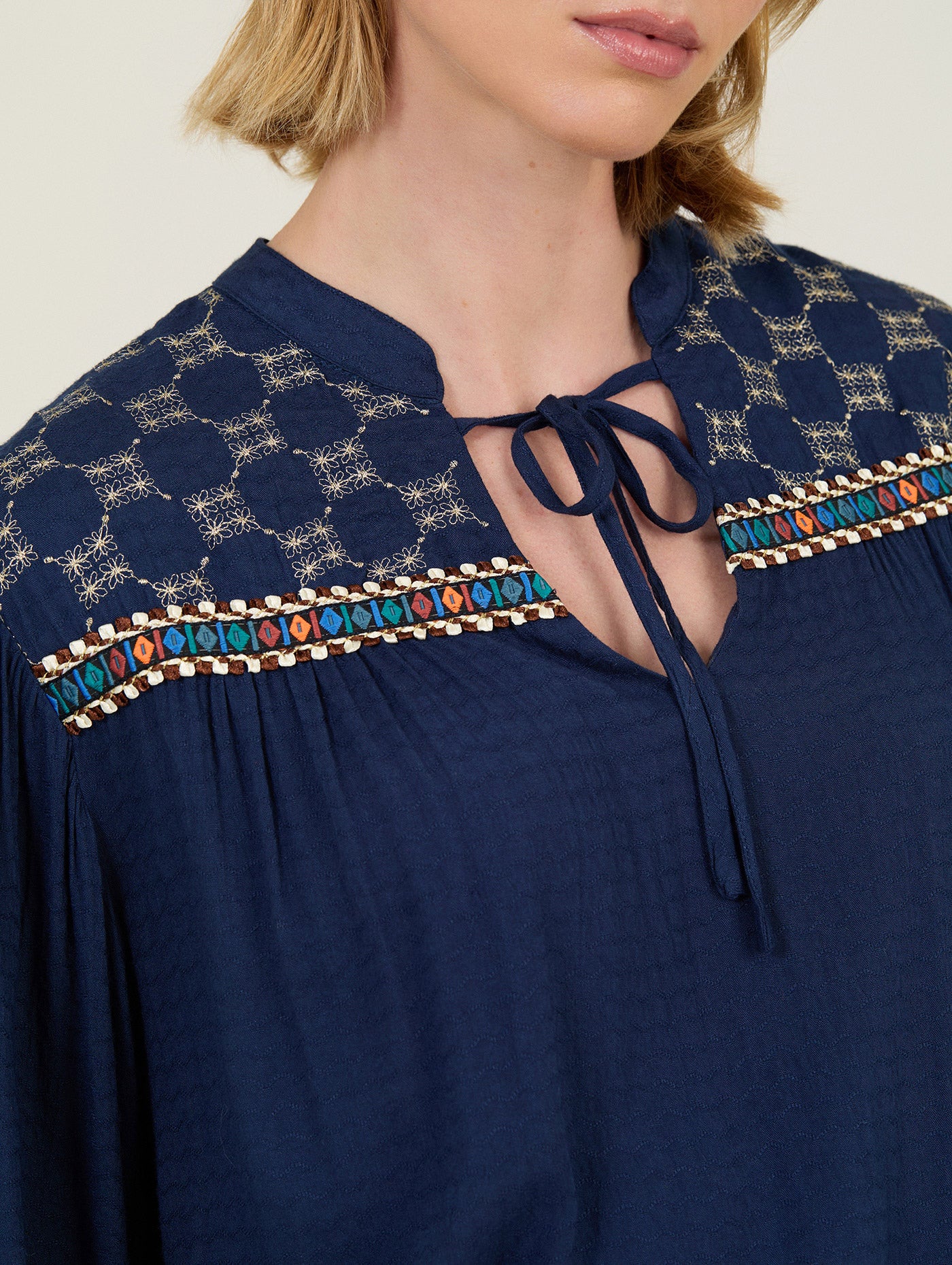 BLUSA CON BORDADO Y FORNITURAS